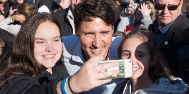 Prime Minister Justin Trudeau gets a self taken with young women at a picnic in Rouyn-Noranda, Que., on Aug. 15, 2018.