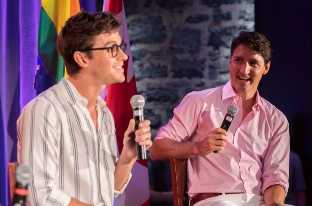 Prime Minister Justin Trudeau laughs as he listens to television personality Antoni Porowski during a party fundraiser in Montreal on Sunday, August 19, 2018.