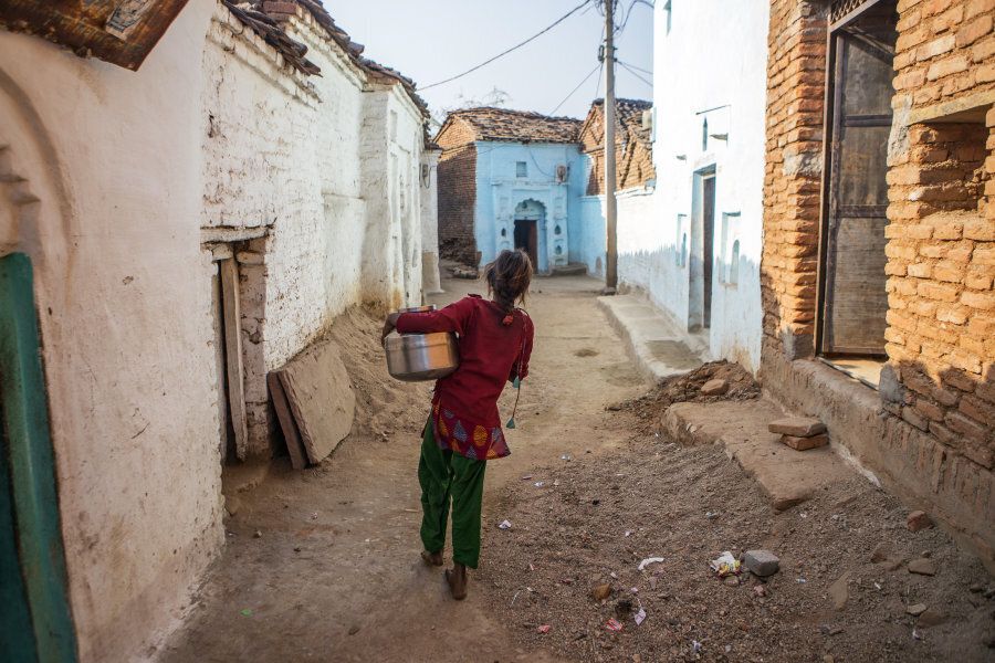 A young woman carries a pot filled with water through the village of Shyampura in Tikamgarh, Madhya Pradesh, India, on Feb. 9, 2016.