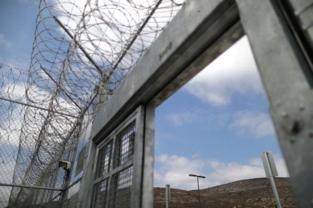 Razor wire sits on top of the entrance an immigration detention center in California.