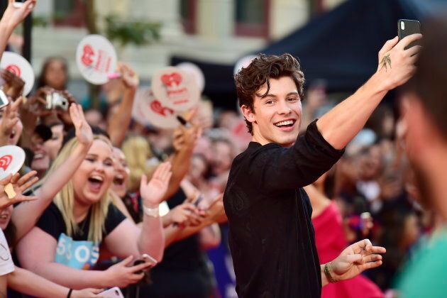 Shawn Mendes takes a selfie with fans.