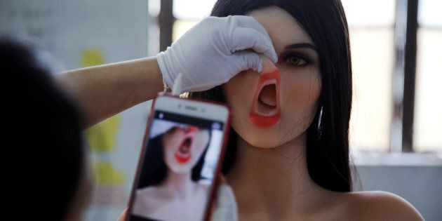 A worker takes a photo of a sex doll at the WMDOLL factory in Guangdong, China, on July 11, 2018.