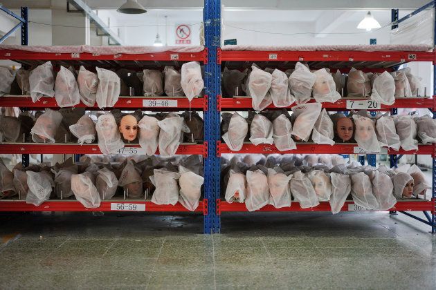Various doll heads covered with dust bags are seen on shelves at the WMDOLL factory in Guangdong, China on July 11, 2018.
