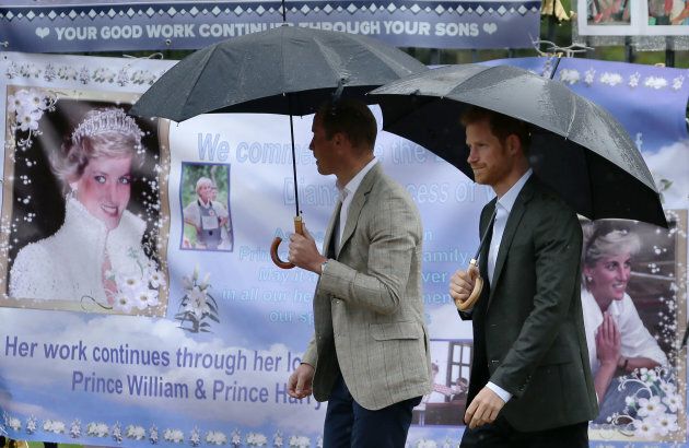 Prince William and Prince Harry look at tributes left by members of the public at one of the entrances of Kensington Palace to mark the coming 20th anniversary of the death of Diana, Princess of Wales, in London on August 30, 2017.