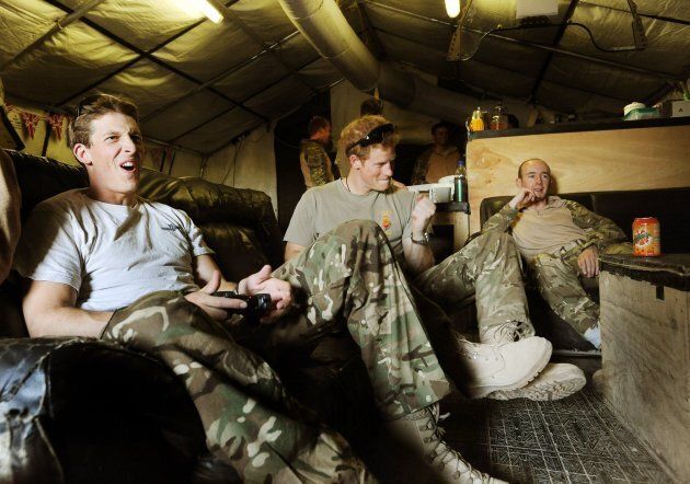 Prince Harry plays video games with Captain Simon Beattie, left, and Sargeant James John in the VHR (very high readiness) tent at the British controlled flight-line at Camp Bastion in Afghanistan.