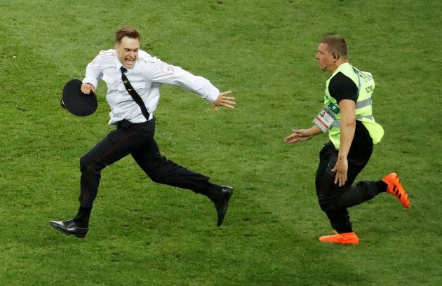 Pitch invader Pyotr Verzilov is chased by a steward during the final.