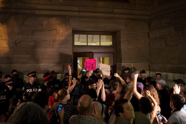 Police block a doorway as protesters demand entry to Queens Park after the public gallery was cleared and closed to onlookers as the Ontario legislature holds a midnight session to debate a bill that would cut the size of Toronto city council from 47 representatives to 25, in Toronto on Sept. 17, 2018.