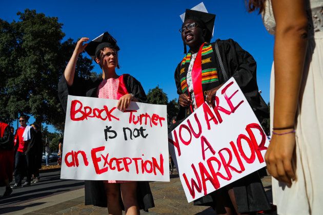 Stanford Miriam Natvig, left, and Jemima Oslo, right, carry signs in solidarity for a Stanford rape victim during graduation ceremonies on June 12, 2016.