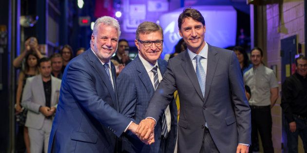 Prime Minister Justin Trudeau poses with Quebec Liberal Leader Philippe Couillard and CAE Inc. president and CEO Marc Parent after a news conference at CAE Inc., in Montreal on Aug. 8, 2018.