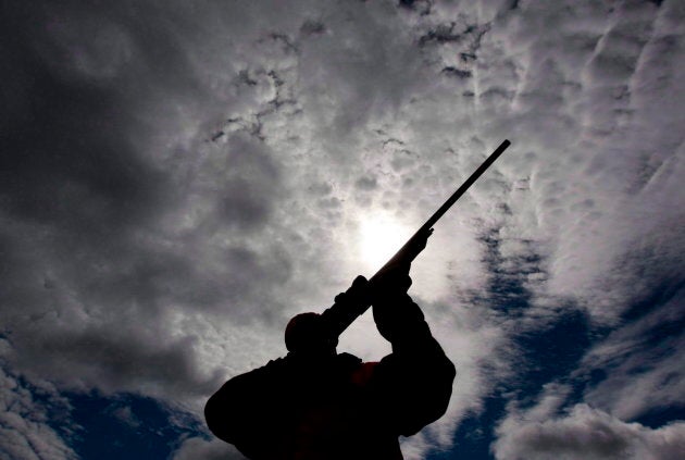 A man checks the sight of his rifle at a hunting camp property in rural Ontario, west of Ottawa, on Sept. 15, 2010.