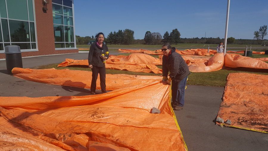 Kara McShaw Plourde (left) donated tarps for Dunrobin residents to use to protect their homes from expected rain.