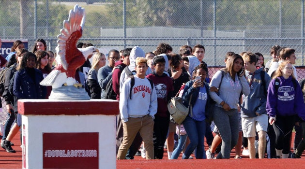 Students walk out of Marjory Stoneman Douglas High School as part of a National School Walkout to honor the 17 students and staff members killed at the school in Parkland, Florida.