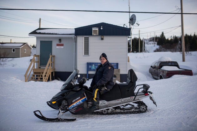 RCMP Cpl. Mike McKee, one of two officers posted in Rigolet, sits on his snowmobile in front of the RCMP detachment in the remote Inuit community on the northern coast of Labrador on Monday, March 26, 2018.