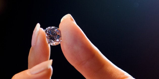 A Sotheby's auction house employee holds 'Premier Blue', the world's largest round fancy vivid blue diamond, during a photocall at the auction house in central London, on September 9, 2013. The diamond weighs in at 7.59 carats and is a round brilliant-cut internally flawless fancy vivid blue, with an expected sale price of GBP12m (14.25m euros/18.8m USD). The diamond will be offered for sale in Hong Kong on October 7, 2013. AFP PHOTO/Leon Neal (Photo credit should read LEON NEAL/AFP/Getty Images)