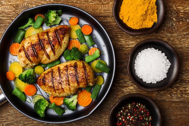 Grilled chicken breast with vegetables in a pan.