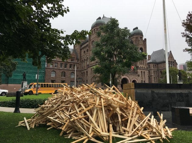 A pile of crosses lies in front of Ontario's legislature on Oct. 1, 2018.