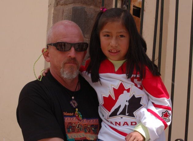 Reeleder poses with a young girl in Peru, who's wearing a hockey jersey donated by Hayley Wickenheiser.