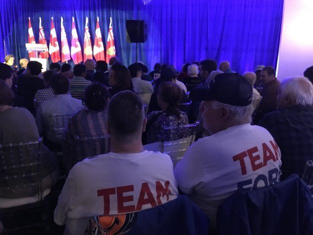 Two men in matching "Team Ford" t-shirts attend a rally celebrating Premier Doug Ford's first 100 days in office in Etobicoke on Oct. 9, 2018.