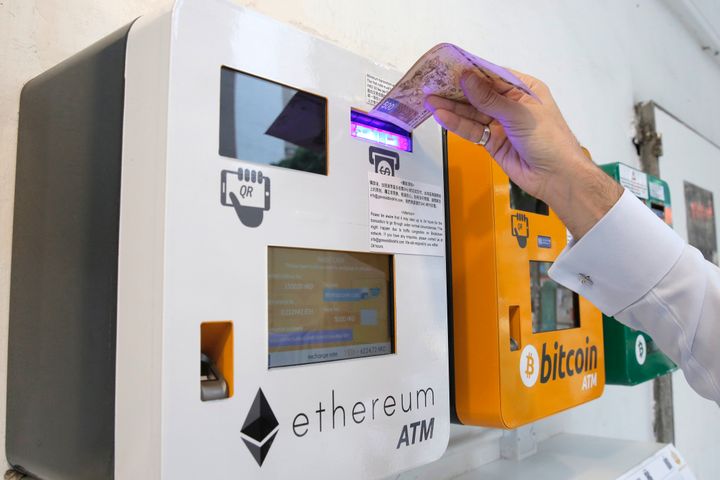 A man uses the Ethereum ATM in Hong Kong, Friday, May 11, 2018.