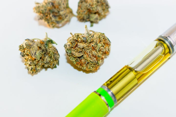 Marijuana bud with THC oil filled vape pen.