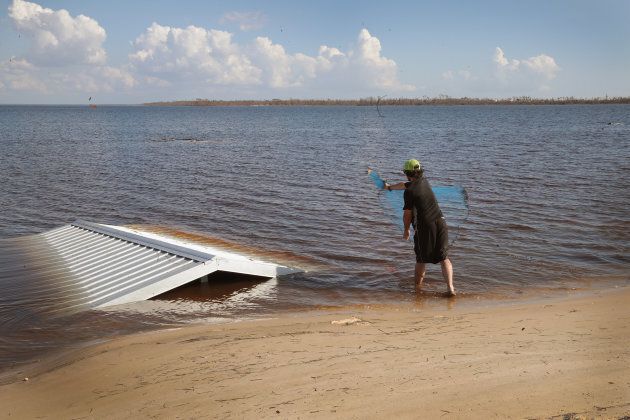 A man works around debris tossed into the water by Hurricane Michael as he fishes in East Bay on Oct. 17, 2018 in Panama City, Florida.