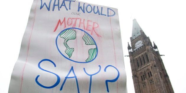 A demonstrator holds up a sign during a call for climate change protest on Parliament Hill in Ottawa on Oct 24, 2009.