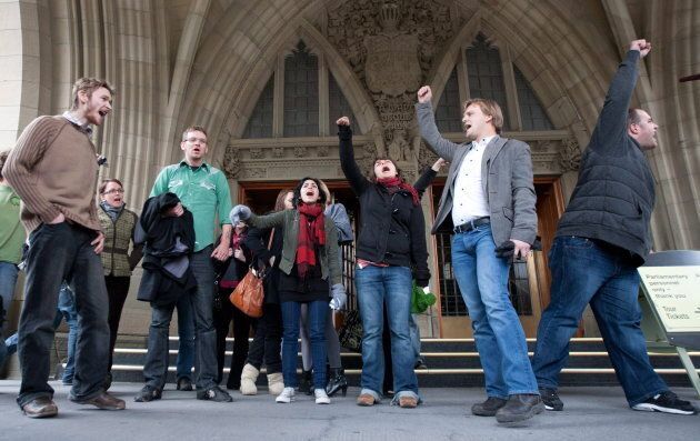A group of youth protestors chant on the steps of the main doors to Parliament after they were escorted out due to disrupting question period in the House of Commons on Parliament Hill in Ottawa on Oct. 26, 2009.