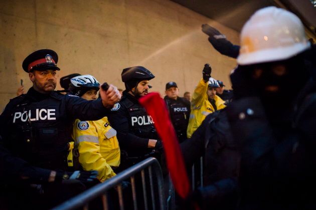 Police pepper spray protesters as they clash prior to a Toronto Munk debate featuring Steve Bannon and conservative commentator David Frum in Toronto on Nov. 2, 2018.