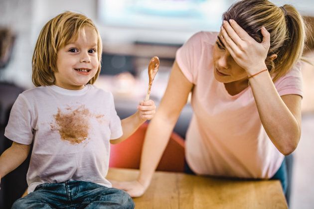 Small boy stained himself with chocolate while his mother is in disbelief.