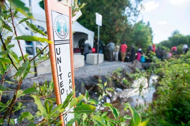 A line of asylum seekers from Haiti wait to cross the Canada/U.S. border near Champlain, NY on Aug. 6, 2017.