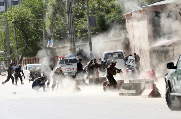 Security forces run from the site of a double suicide attack in Kabul, Afghanistan, on April 30, 2018.