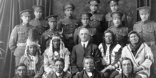 Recruits from File Hills, Sask. pose with elders and a government representative in a 1915 photo from...