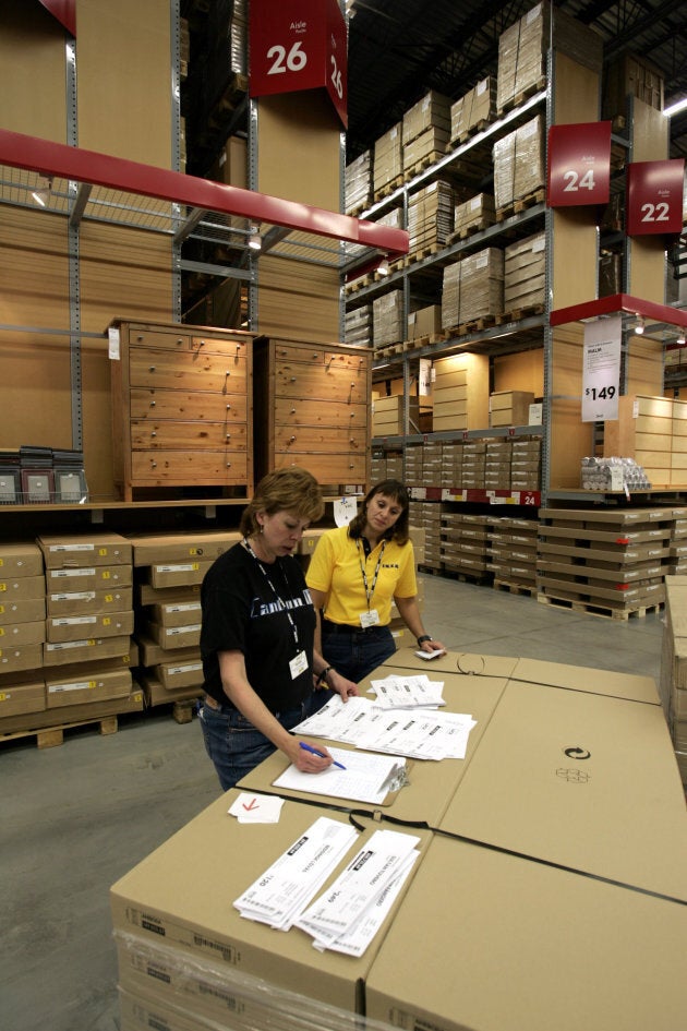 Ikea employees look over labels at the furniture store in Canton Township, Mich.