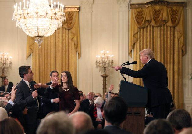 A White House staff member reaches for the microphone held by CNN's Jim Acosta as he questions U.S. President Donald Trump on Nov. 7, 2018.