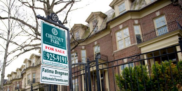 A for sale sign outside a rowhouse in Toronto. After showing signs of a rebound over the spring and summer months, Canada's national housing market has slipped back into downturn mode, two new reports released Thursday show.