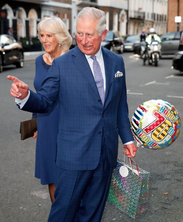 Prince Charles, with his wife Camilla, holds a birthday gift on his 70th birthday at Spencer House in London on Wednesday.