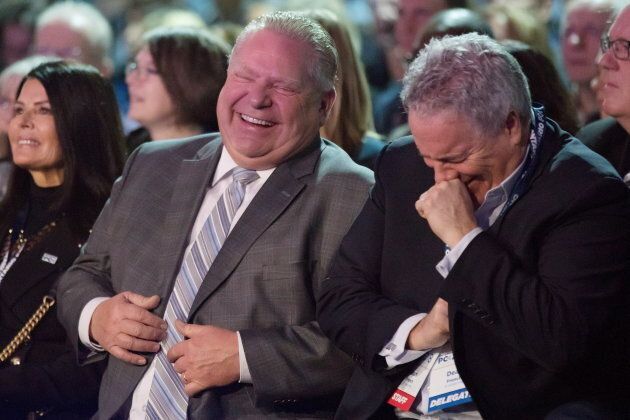 Ontario Premier Doug Ford and his chief of staff Dean French share a joke as they wait to hear federal Conservative Leader Andrew Scheer speak at the Ontario PC Convention in Toronto on Nov. 17, 2018.