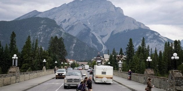 Pedestrians cross the street in Banff, Alta., in Banff National Park on July 21, 2017.