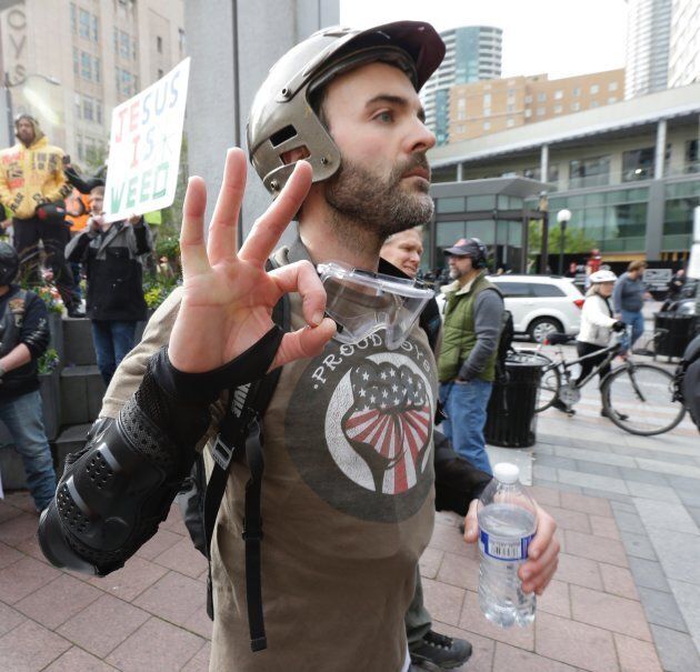 A man wearing a shirt supporting the Proud Boys conservative group makes a hand sign as he takes part in a May Day protest in Seattle May 1, 2017.