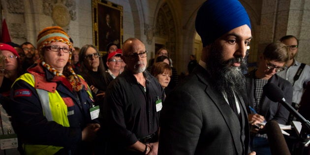 Surrounded by members of Canada Post NDP leader Jagmeet Singh listens to a question from the media about back to work legislation on Nov. 23, 2018 in Ottawa.