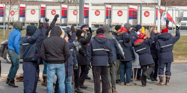 Striking Canada Post workers walk the picket line in front of the Saint-Laurent sorting facility in Montreal on Nov. 15, 2018.