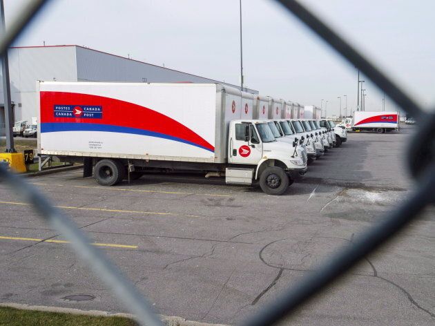 Idle Canada Post trucks sit in the parking lot of the Saint-Laurent sorting facility in Montreal as rotating strikes hit the area on Nov. 15, 2018.