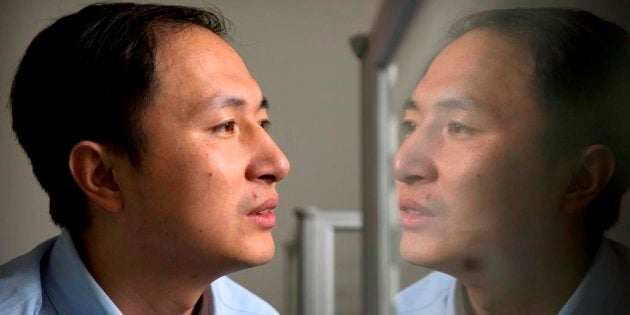 He Jiankui is reflected in a glass panel as he works at a computer at a laboratory in Shenzhen in southern China's Guangdong province. Canadian researchers have added their voices to widespread international condemnation of a Chinese scientist who says he helped create genetically modified twin girls using a gene-editing tool known as CRISPR.