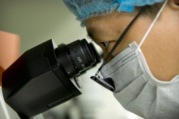 Qin Jinzhou, an an embryologist in He Jiankui's lab, looks through the lenses of a microscope as he works at a laboratory in Shenzhen in southern China's Guangdong province.