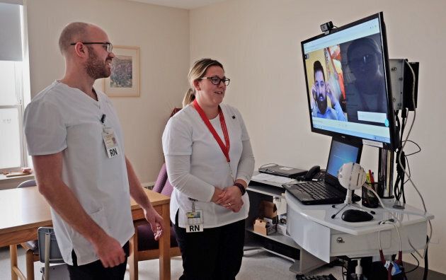 Nurses at P.E.I.'s Western Hospital chat with a doctor who appears on a tele-rounding cart.