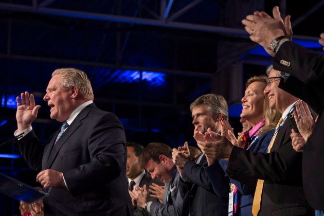 Ontario Premier Doug Ford, left, receives the applause of his caucus as he addresses the Ontario PC Convention in Toronto, on Nov. 16 , 2018.