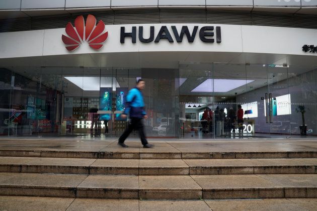 A man walks by a Huawei logo at a shopping mall in Shanghai, China, Dec. 6.