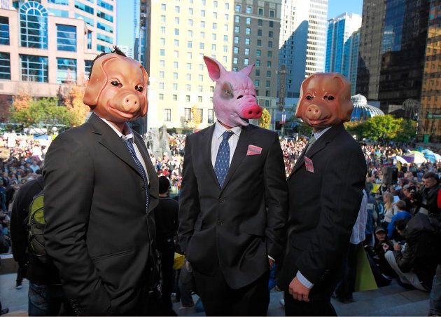 Protesters wear pig masks and business suits as thousands of people participate in the Occupy Vancouver protest on Oct. 15, 2011 in Vancouver, B.C.