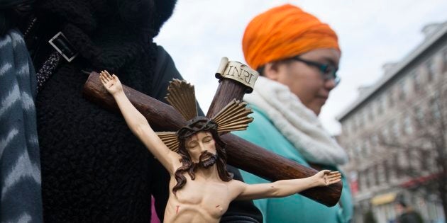 A woman holds a crucifix during a Montreal gathering, Jan. 12, 2014, to oppose a law that would ban the wearing of religious symbols and clothing in all public institutions. A similar law is proposed now by the current provincial government there.