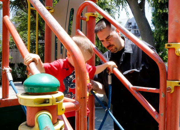 In this Monday, June 4, 2018, photo, Glen Wood, a Canadian who has lived in Japan for 30 years, plays with his son at a Tokyo park.